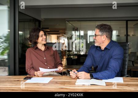 Happy professional executives team discussing papers working in office. Stock Photo