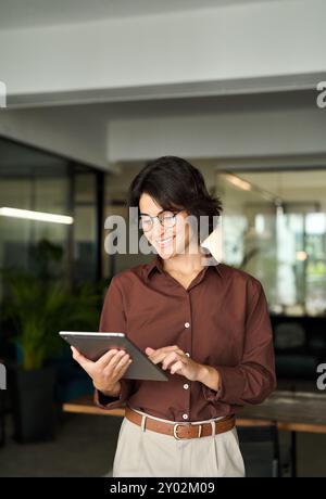 Smiling busy female professional executive using tablet working in office. Stock Photo