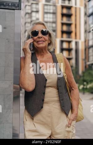 Chic Senior Woman Having a Great Time Enjoying Urban Life with Her Smartphone in Hand Stock Photo