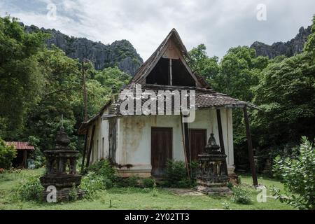 Rustic Temple An old Buddhist temple nestled among lush greenery and dramatic ...