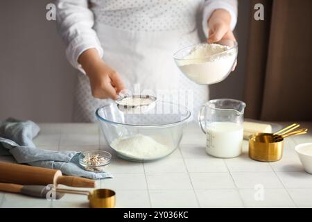 Woman preparing traditional cinnamon rolls in kitchen Stock Photo