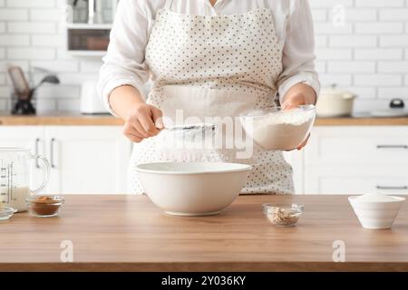Woman preparing traditional cinnamon rolls in kitchen Stock Photo