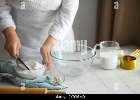 Woman preparing traditional cinnamon rolls in kitchen Stock Photo