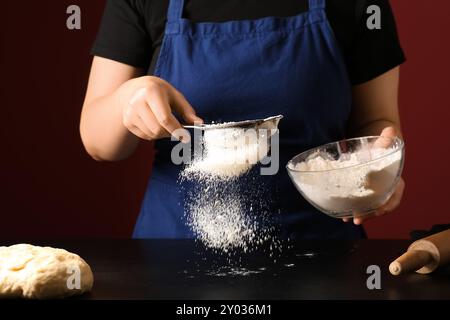 Woman preparing traditional cinnamon rolls in kitchen Stock Photo