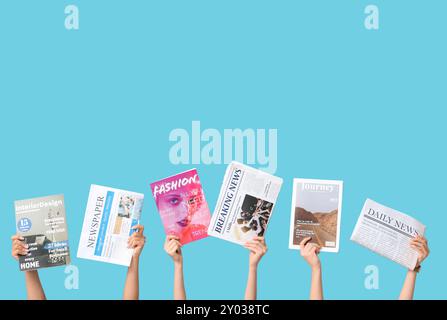 Female hands with different magazines and newspapers on blue background Stock Photo
