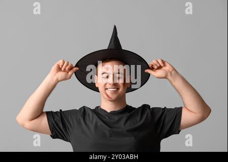 Young man dressed for Halloween as wizard on light background Stock Photo