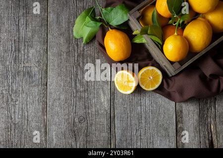 Fresh ripe yellow lemon fruits with leaves on wooden background Stock Photo