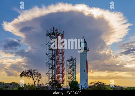A large dramatic storm cloud over a lighthouse and signal towers at Queenscliff on the Bellarine Peninsula in Victoria, Australia Stock Photo