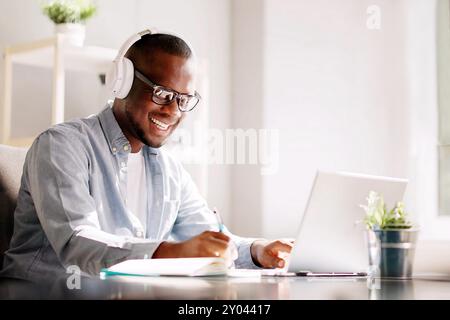 Remote African-American Marketer Thrives in Virtual Training Sessions and Webinars at Home Office Using Smart Laptop Stock Photo