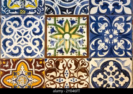 A colorful mosaic tiles wall with different colors and design. Ancient multicolored mosaic tiles close up. Mosaic ceramic tiled wall. Nobody Stock Photo