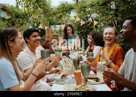 Happy group of male and female friends enjoying drinks while celebrating at dinner party Stock Photo