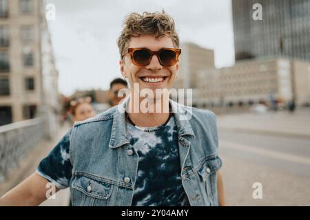 Portrait of happy young man in sunglasses walking on street Stock Photo