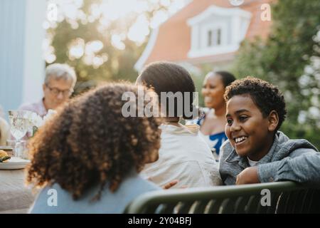 Smiling boy talking with female friend during dinner party in garden Stock Photo