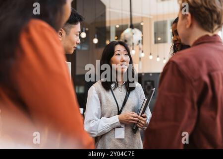 Businesswoman discussing strategies with male and female delegates during seminar at convention center Stock Photo