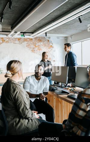 Male and female computer programmers discussing in office Stock Photo