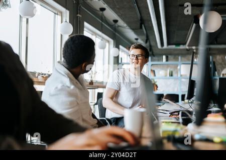 Male programmer talking with colleague while working in tech startup office Stock Photo