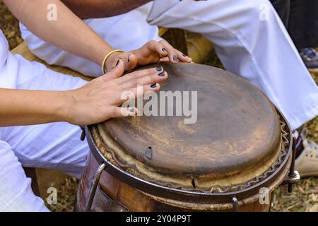 Young woman percussionist hands playing a drum called atabaque during brazilian folk music performance Stock Photo