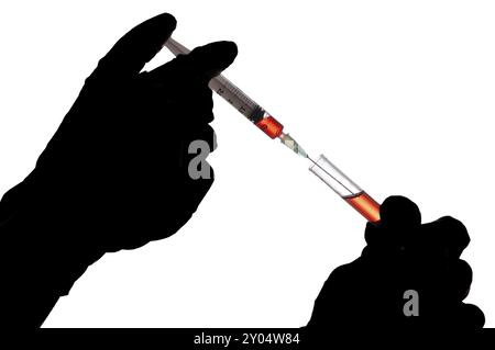 Hand holding a syringe and taking a blood sample from a tube for analysis Stock Photo