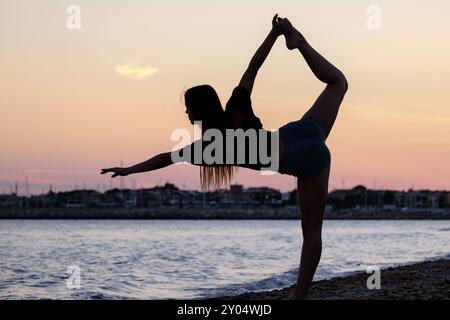 Young woman practising yoga, Sa Rapita beach, Campos, Mallorca, Balearic islands, Spain, Europe Stock Photo