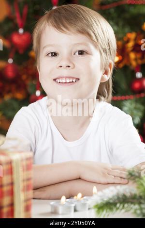 Portrait of happy boy against Christmas lights background Stock Photo