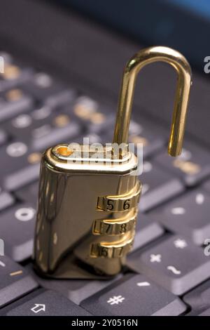 A golden padlock on a black notebook keyboard Stock Photo