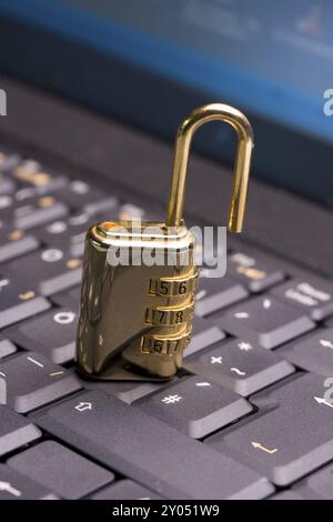 A golden padlock on a black notebook keyboard Stock Photo