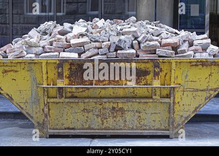 Over filled skip container with brick debris Stock Photo