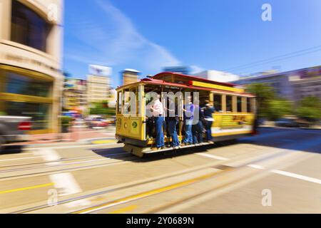 San Francisco, USA, May 18, 2016: Motion blur pan of moving cable car full of people going past Union Square up Powell Street on a sunny day in Califo Stock Photo