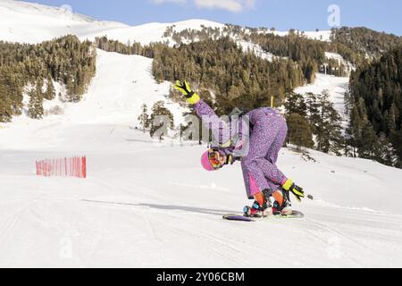 Beautiful beginner snowboarder girl in caucasian mountains Stock Photo