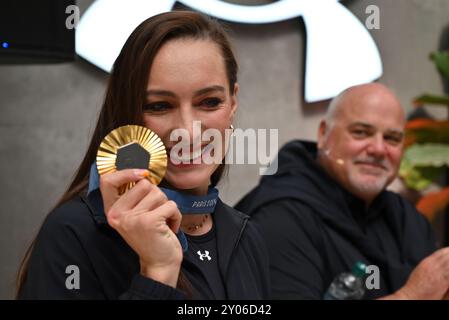 Johannesburg, Gauteng, South Africa. 31st Aug, 2024. Olympic Gold medalist, TATJANA SMITH shows her medal at a welcome home event held by her sponsor, Under Armour at their flagship store in Sandton City, Johannesburg. Behind her is her coach, ROCCO MEIRING (Credit Image: © Neil McCartney/ZUMA Press Wire) EDITORIAL USAGE ONLY! Not for Commercial USAGE! Stock Photo