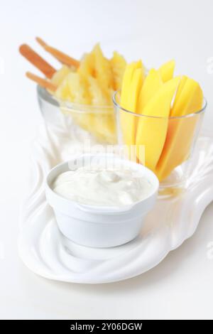 Healthy snack Pineapple skewer with mango strips and quark or yoghurt Stock Photo