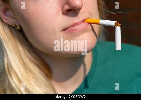 Breaking a Cigarette in Half. Smoking a broken Cigarette. Man and woman  smoking a broken cigarette. Stop smoking. Quitting cigarettes Stock Photo
