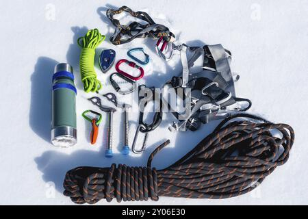 Close-up of winter climbing equipment on fresh snow on a sunny day. Carbines with a rope gazebo and zhumar as well as other adaptations when practicin Stock Photo