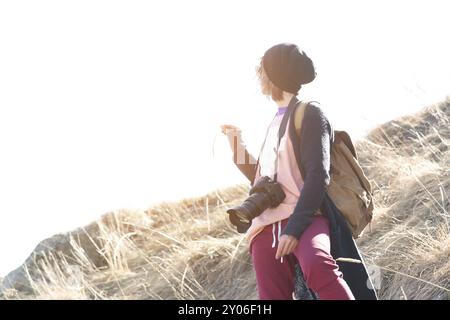 Woman hipster-photographer with dslr camera. Stylish girl in sunglasses with a camera on the nature Stock Photo