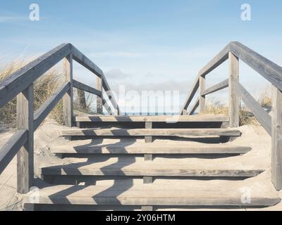 Dune with wooden stairs, pathway to the beach, sunny winter morning Stock Photo