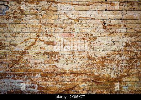 Background wall from an ancient yellow vintage brick with rusty corrosion patterns on the surface. Textured background in grunge style. Procurement fo Stock Photo
