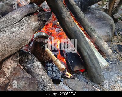 Brew coffee in a Turk on an open fire. Stock Photo