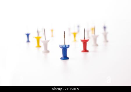 Colorful push pins on a white background, selective focus on the foreground Stock Photo