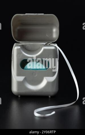 Plastic open box with dental floss inside front view isolated on black studio background Stock Photo