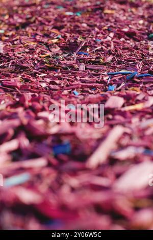 Textured background decorative colored sawdust for finishing flowerbeds in the winter season. Red and maroon sawdust Stock Photo