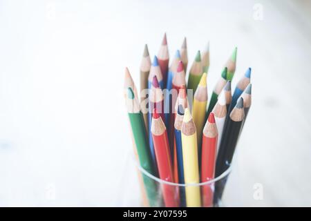 Colored pencils in a can on rustic wooden table, white background Stock Photo