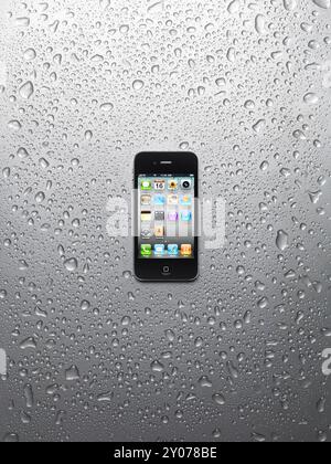 Apple iPhone 4 smartphone with desktop icons on its display isolated on wet shiny steel background. High quality photo Stock Photo