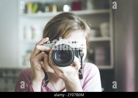 Young girl is taking a picture with a vintage camera Stock Photo