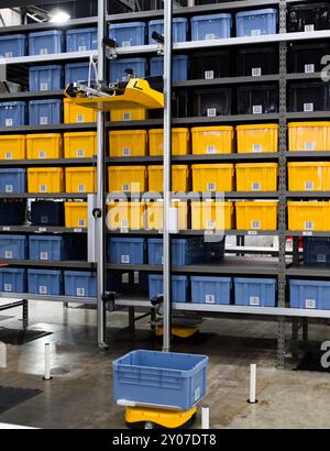 Autonomous robot picking materials from multi-layer rack in modern industrial warehouse. Stock Photo