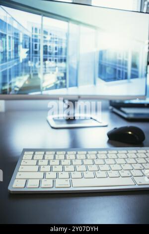 Freelancer?s workplace: Keyboard in the foreground, blurry screen in the background Stock Photo