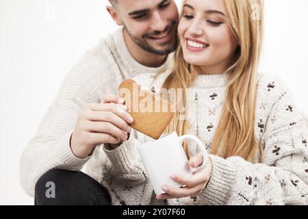 Couple dipping cookies into mug Stock Photo