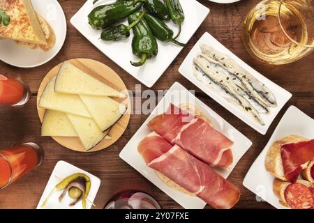 Spanish tapas and wine, the cuisine of Spain shot from the top on a dark rustic wooden background Stock Photo