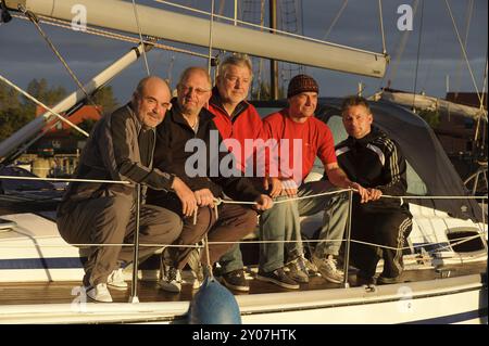 Crew of a sailing yacht on the upper deck in the morning sun Stock Photo