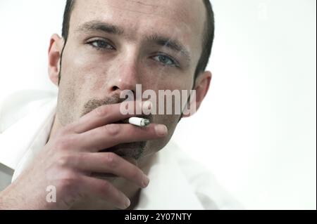 Young man with cigarette looks into the camera Stock Photo