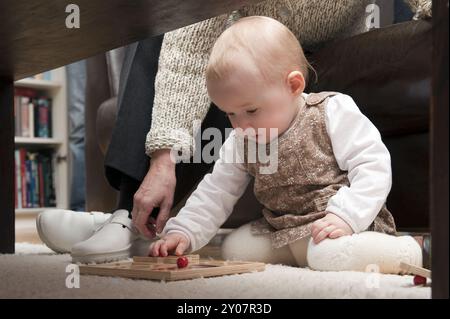 Little girl playing under a table Stock Photo